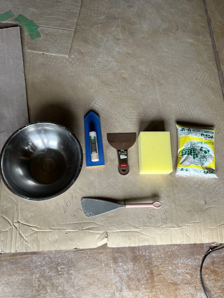 タイル目地を施工するために使ったスポンジ、ヘラ、ボウル、ヤスリなどの道具