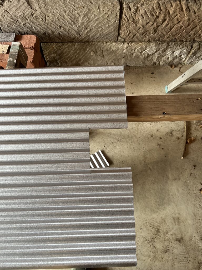 グラインダーでガルバ波板をカットしているDIY作業中の様子。