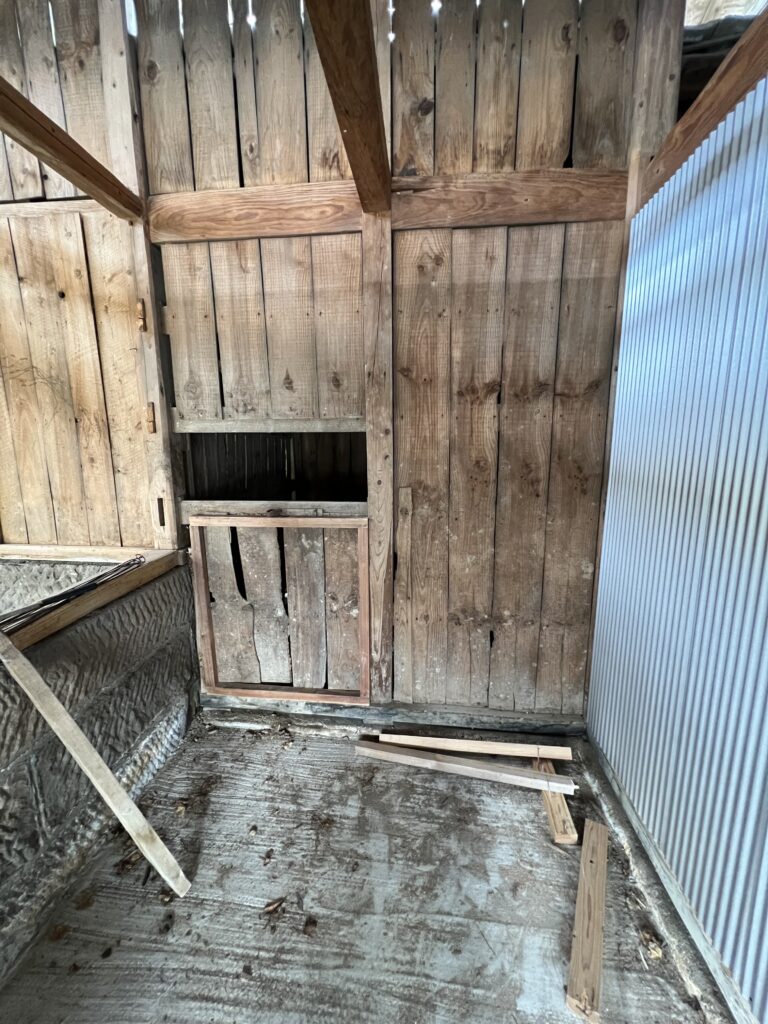 納屋の内壁に木枠を組んでいる様子。古い柱に合わせて調整しながらガレージの下地をつくっている。