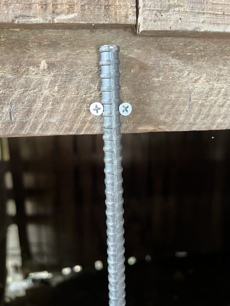 鉄筋を上下の木材でビス止めして固定している様子。簡易的ながら強度もある取り付け方法